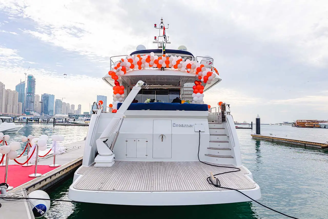 A yacht decked out with wedding decorations pulls up to a Dubai marina