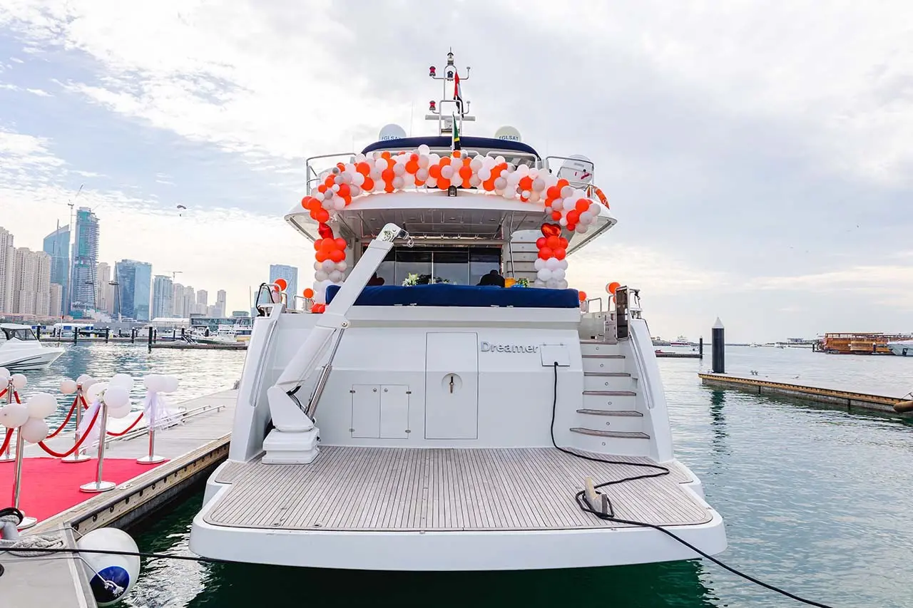 A yacht decked out with wedding decorations pulls up to a Dubai marina