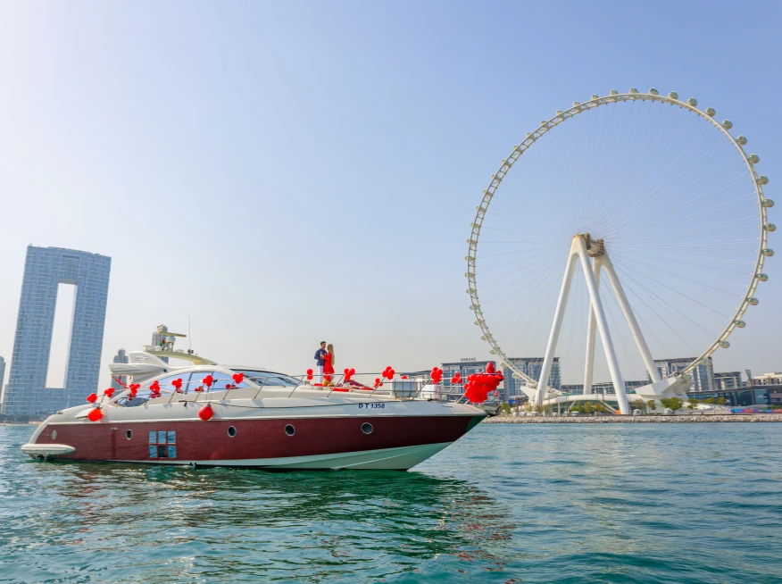 A decorated Dubai yacht cruises past the Ain Dubai.