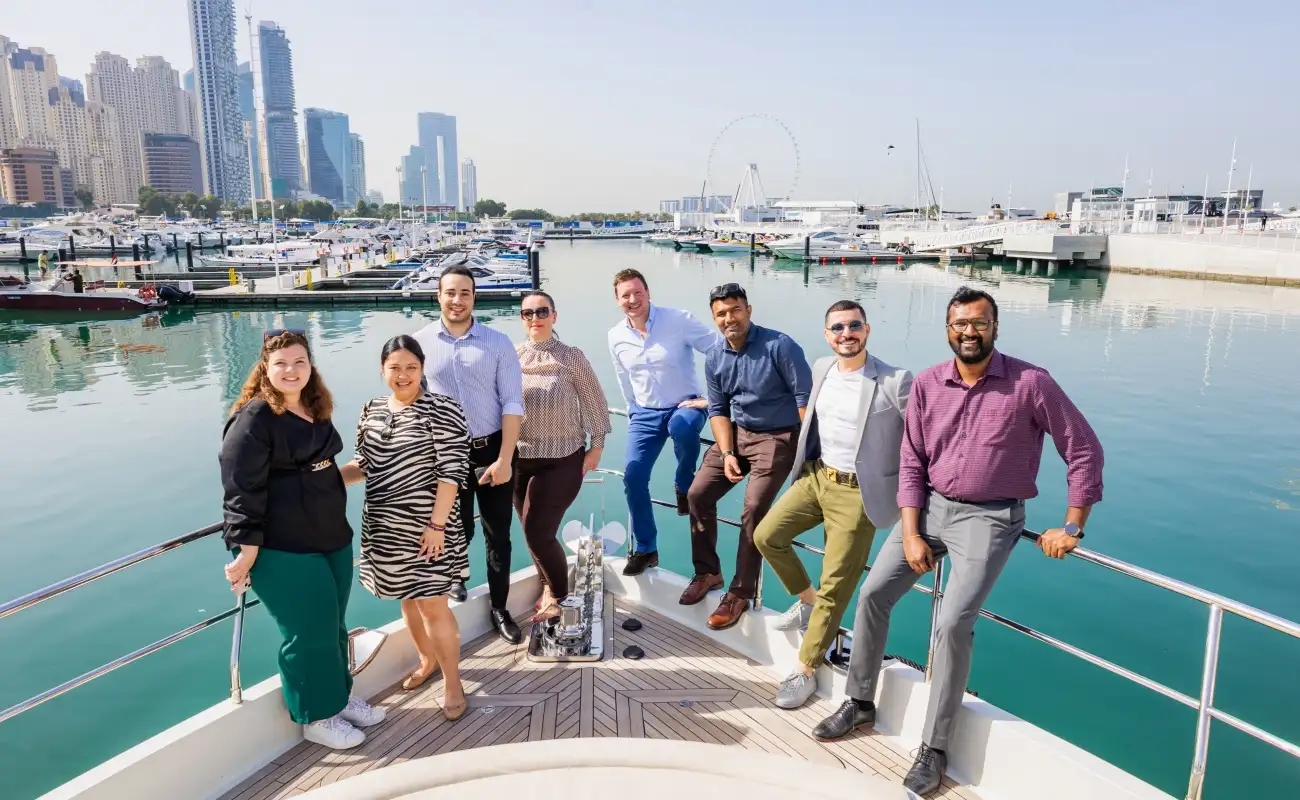 Team enjoying a private yacht rental in Dubai Marina with city skyline in the background.