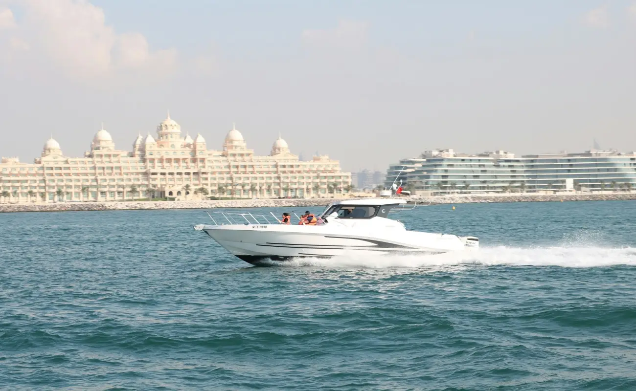 Speed boat cruising near Palm Jumeirah, Dubai, with luxury hotels in the background.