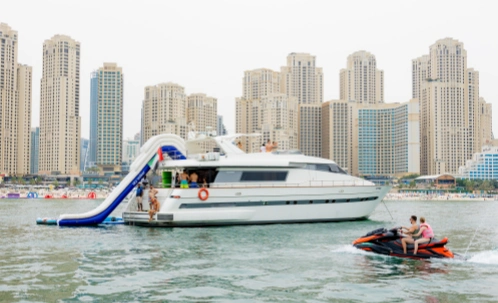 a guest slides into the water from the private waterslide during dubai yacht cruise