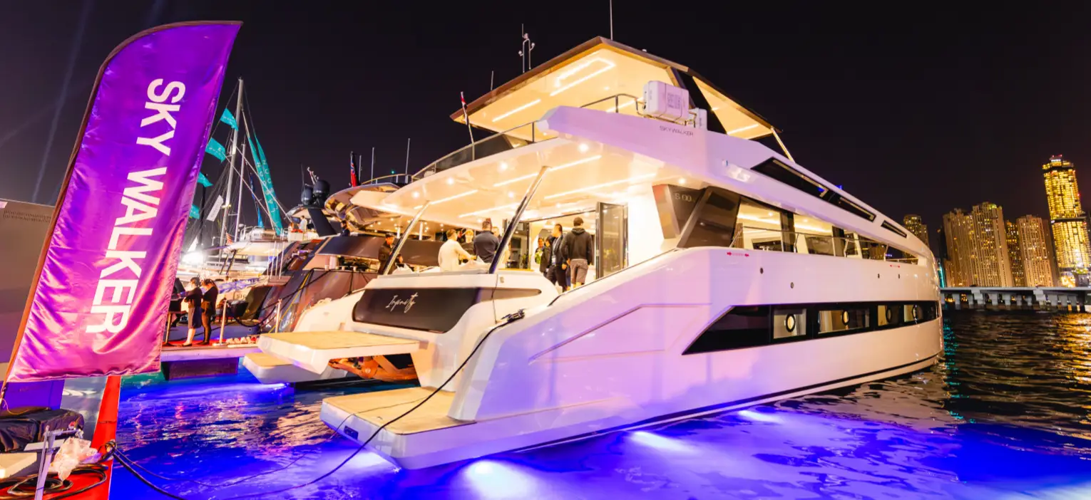 a luxury yacht at dubai marina, illuminated by warm lights and underwater blue accents at night, perfect for a 2-hour luxury cruise experience.